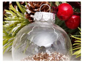 Primer plano de una bola de Navidad transparente llena de purpurina dorada brillante