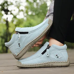 Detail showing side zipper and handmade stitching on light blue high-top casual shoes