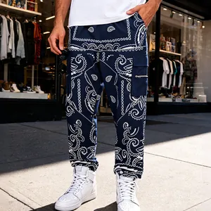 Close-up of navy blue paisley bandana cargo pants with zip pocket on male model.