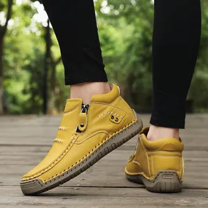 Close-up of yellow high-top casual leather shoes with zipper and hand-stitched rubber sole.