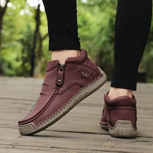 Macro view of wine red hand-stitched high-top shoes detail shown in natural outdoor lighting.
