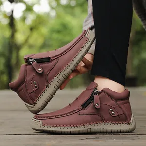 Close-up view of burgundy high-top leather leisure shoes featuring side zipper and hand stitching