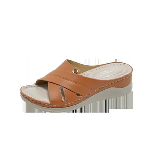 Sandales compensées marron confortables pour femmes avec brides croisées et bouton doré.