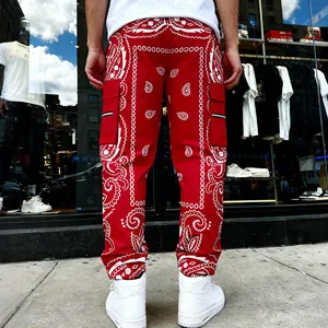 Rear view of red men's cargo pants with white paisley print in a street urban setting.