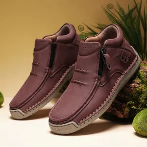 Detailed side view of brown high-top leather leisure shoes with side zipper on mossy rock
