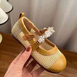 Primo piano di ballerine gialle da bambina con cinturino di cristalli e dettagli in mesh