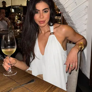 Detail of white halter neck top with elegant gold ring shoulder accents