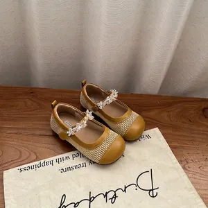 Dettaglio di ballerine Mary Jane giallo senape per bambina con cinturino floreale.