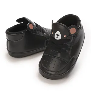 Gros plan de baskets noires pour bébé avec motif ours mignon sur la languette