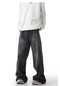 Detailed shot of men's baggy straight leg jeans with a unique yellow mud wash finish