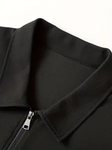 Detailansicht einer schwarzen Waffelstrick-Herrenjacke mit Polokragen und silbernem Reißverschluss