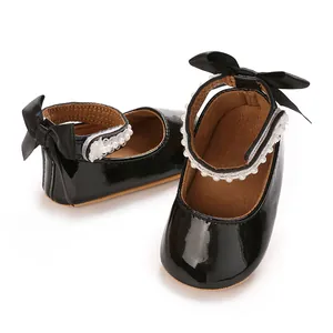 Detailed view of baby black patent leather princess shoes with pearl straps and bows
