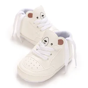 Gros plan de chaussures de sport bébé blanches avec motif d'ours mignon et lacets blancs