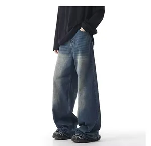 Detailed side view of men's loose straight-leg denim jeans featuring yellow mud dye wash
