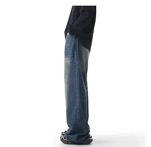 Detail of loose wide-leg denim jeans featuring vintage yellow mud dye washed finish