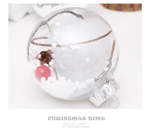 Bola de Navidad transparente con nieve artificial, piña y detalle de baya roja.