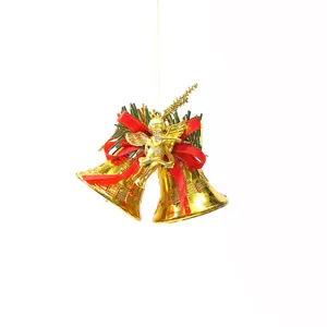 Macro detail showing golden electroplated Christmas bells with red ribbon and angel ornament