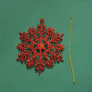 Rote glitzernde Weihnachts-Schneeflocke mit goldener Aufhängeschnur in der Nahaufnahme