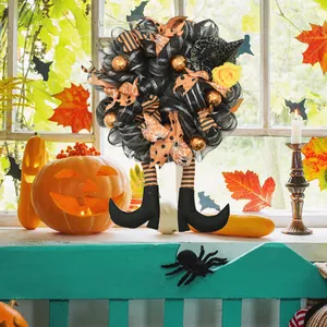 Couronne d'Halloween avec jambes de sorcière et rubans orange et noir pour décoration.