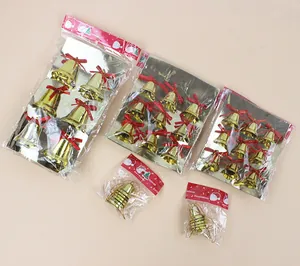 Vista detallada de juegos de campanas navideñas doradas con lazos rojos en bolsas.