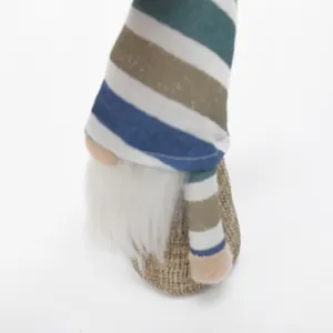 Close-up of Easter gnome plush with striped hat and white faux fur beard on white background