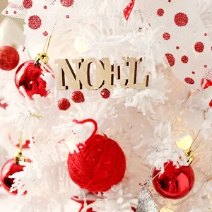 White flocked mini Christmas tree decorated with red balls and wooden Noel sign