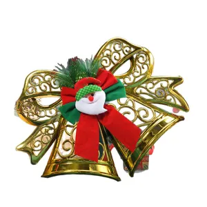 Festive golden Christmas bells ornament featuring a red bow and Santa Claus hanging decor