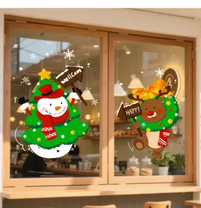 Adesivi statici natalizi con personaggi di pupazzo di neve e renna su una vetrata.