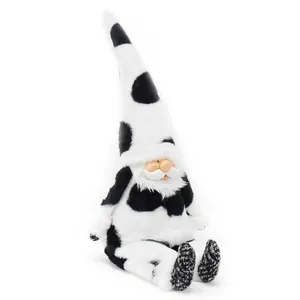 Close-up detail of a cute cow print plush gnome doll featuring a resin face design