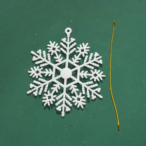 Detailansicht eines weißen Kunststoff-Schneeflocken-Ornaments mit goldener Schnur.