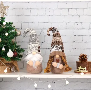 Two handmade Christmas gnomes with coffee cups placed in a festive holiday setting.