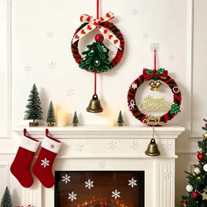 Ghirlande natalizie festive fatte a mano con nastri, campane e alberi sul caminetto