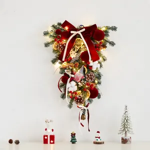 Couronne de Noël inversée lumineuse avec grand nœud en velours rouge sur mur blanc