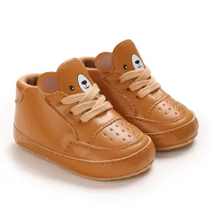 Vue détaillée de baskets bébé en cuir marron à motif d'ours pour garçons de 6 à 12 mois.