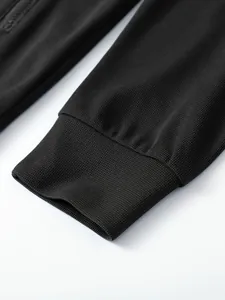 Nahaufnahme von schwarzem Waffelstrick und Rippbündchen an Herren-Sportjacke.