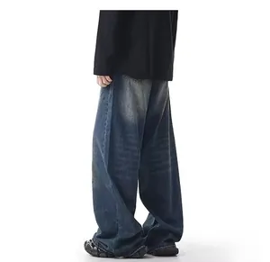 Detailed view of men's loose wide-leg jeans featuring a vintage yellow mud wash.