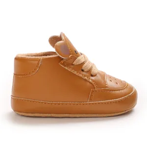 Vue latérale de chaussures de sport pour bébé marron avec design d'oreilles d'ours.