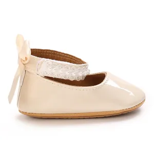 Detailed side view of beige baby girl princess shoes with pearl lace strap and heel bow