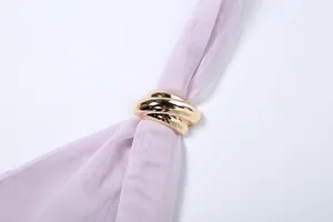 Close-up of golden intertwined buckle on lilac mesh halter neck top detail