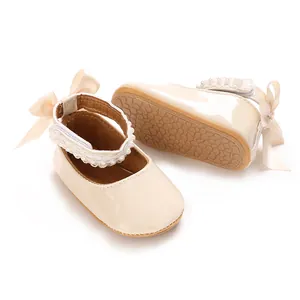 Detail view of cream baby princess shoes with pearl straps and decorative bows