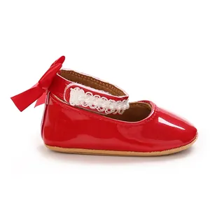 Detailed side view of red patent leather baby girl shoes with bow and pearl accents