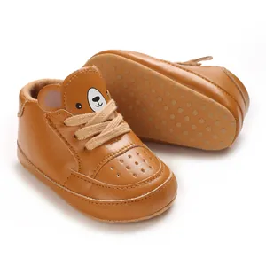 Gros plan sur des baskets bébé marron avec un motif d'ours mignon et des lacets robustes