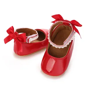 Detailed macro view of red patent baby girl princess shoes with pearls and silk ribbons.