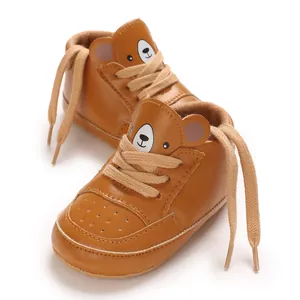 Gros plan de baskets marron pour bébé avec un design d'ours mignon