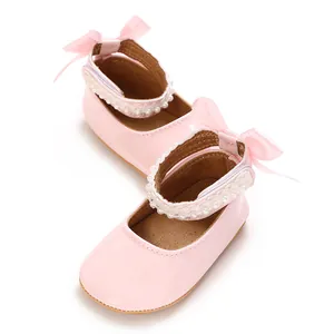 Close-up of pink PU baby princess shoes featuring pearl trim and heel bow details.