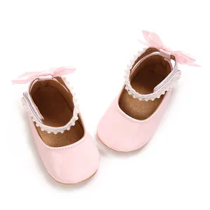 Detail of pink patent PU baby girl princess shoes with pearl straps and silk bows