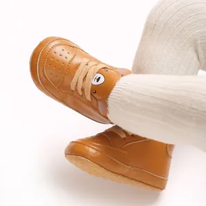 Détail de baskets marron pour bébé avec un joli motif d'ours pour les garçons de 6 à 12 mois.