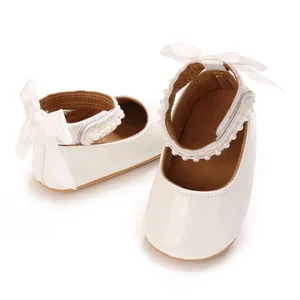 Close-up of white PU baby princess shoes featuring elegant pearl trim and a satin ribbon bow