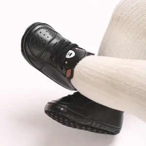 Gros plan de baskets noires pour bébé avec motif ours mignon et semelles antidérapantes