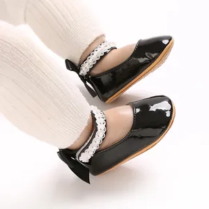 Close-up of baby girl princess shoes with black patent leather and pearl strap.
